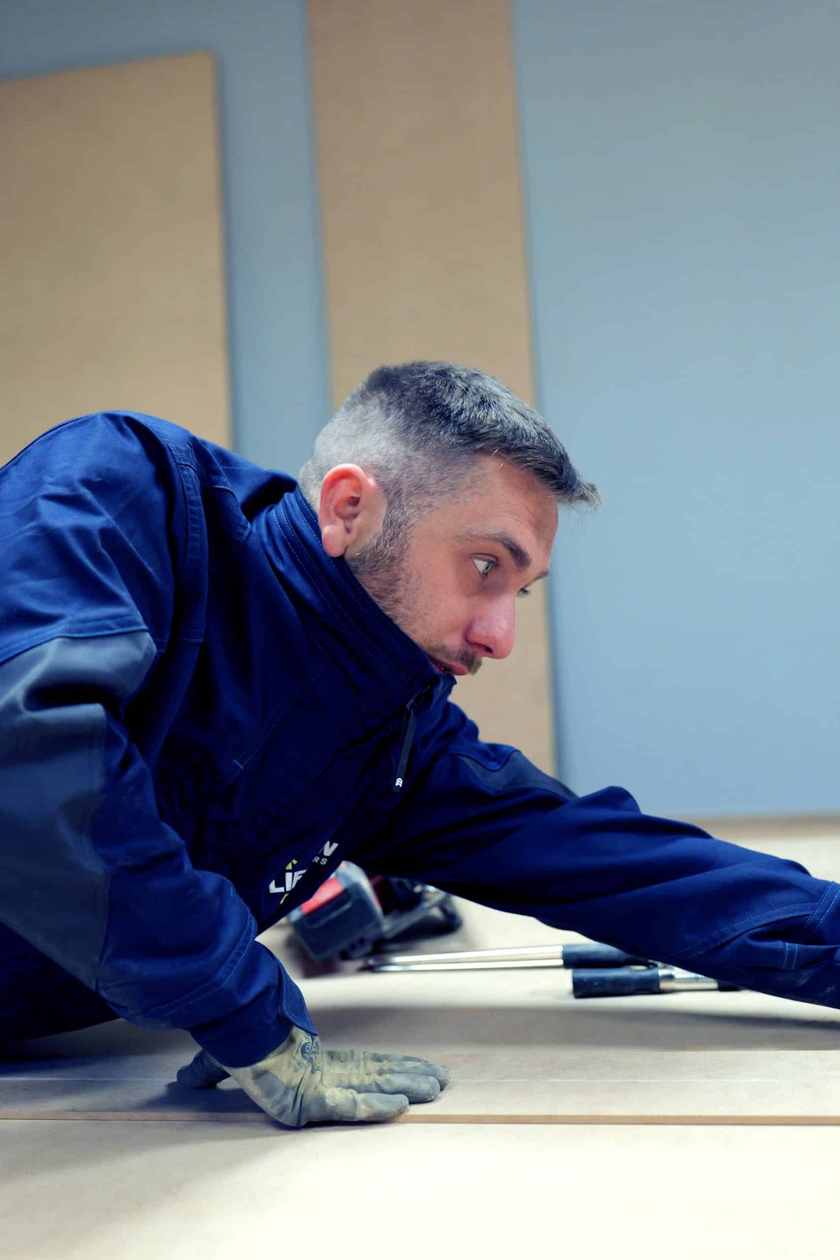 Technicien Liftman découpant des planches de bois