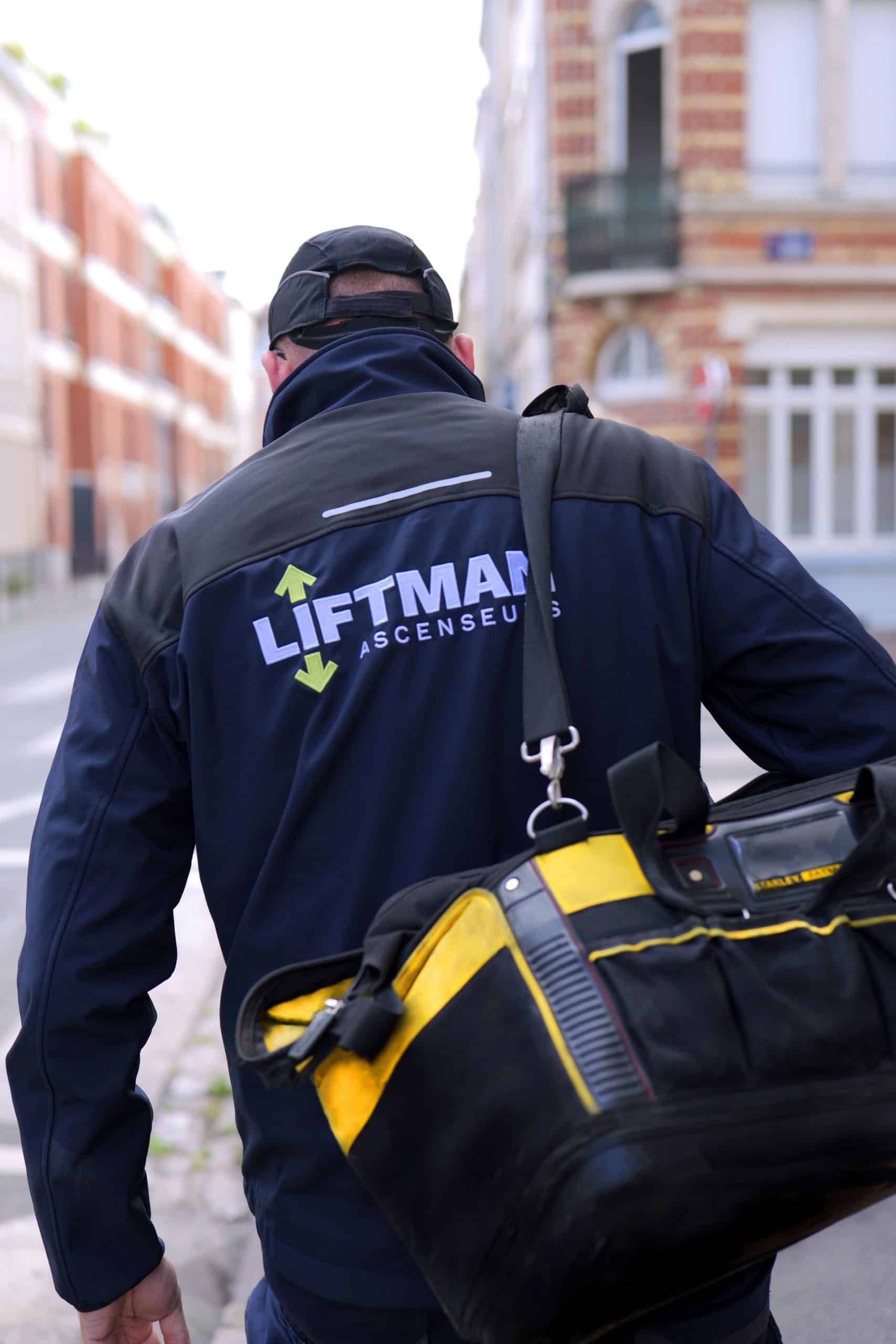 Technicien Liftman de dos marchant vers le lieu d'intervention